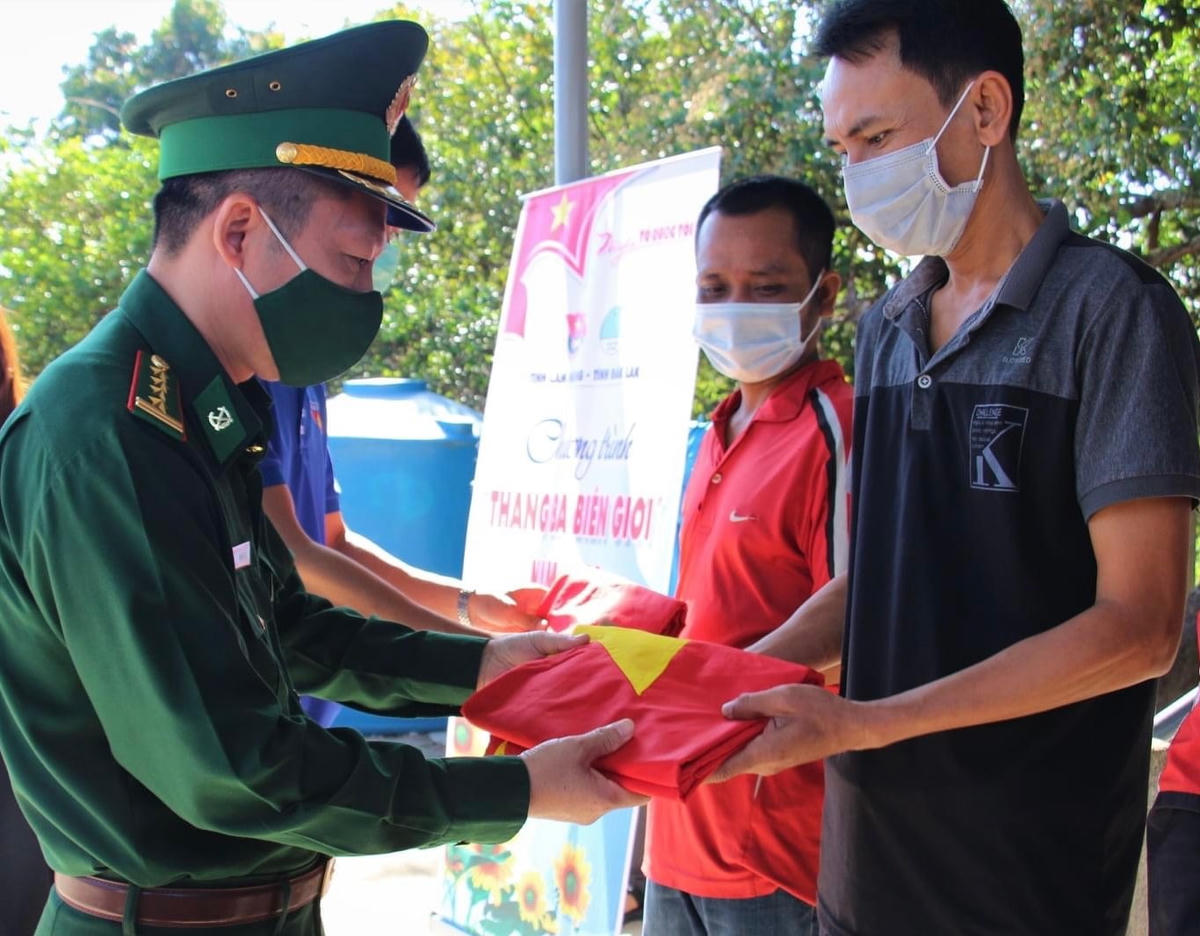 Đại tá Đỗ Quang Thấm, Phó Chính ủy BĐBP tỉnh Đắk Lắk tặng cờ cho bà con nhân dân buôn Đrang Pốk, xã Krông Na, huyện Buôn Đôn.