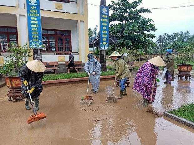 Phụ nữ tham gia dọn dẹp vệ sinh khắc phục hậu quả sau mưa lũ. Ảnh: Võ Dung/TTXVN.  