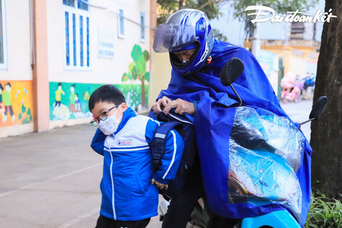 Phụ huynh học sinh đưa con em mình đến trường.