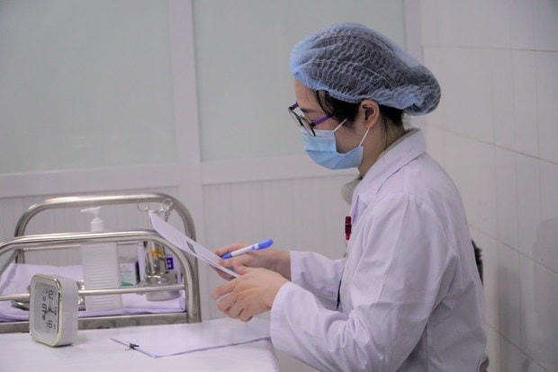 Nhân viên y tế hoàn tất các thủ tục. (Ảnh: Hiếu Hoàng/Vietnam+).