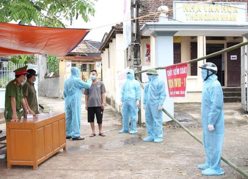 Một người trong thôn được đo thân nhiệt.