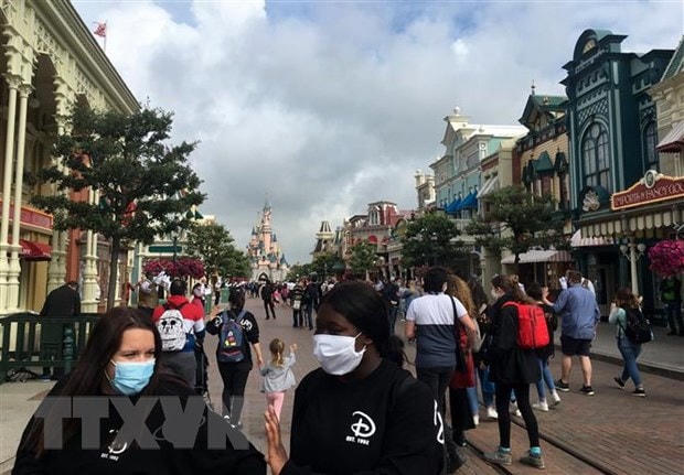 Du khách vẫn phải đeo khẩu trang khi tới thăm công viên Disneyland ở thủ đô Paris. Ảnh: AFP/TTXVN.