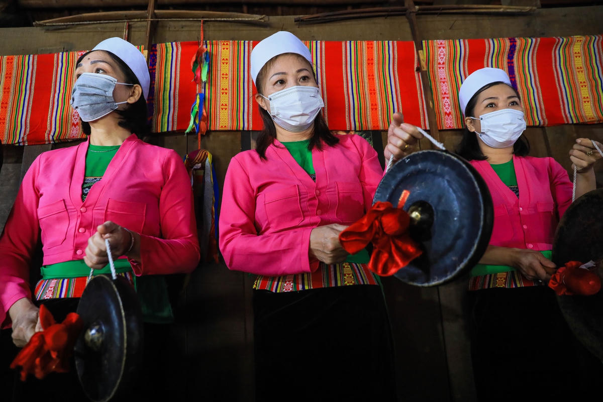 Đội nghi lễ diện trang phục lộng lẫy đứng phía sau thầy mo. Ảnh: Quang Vinh.