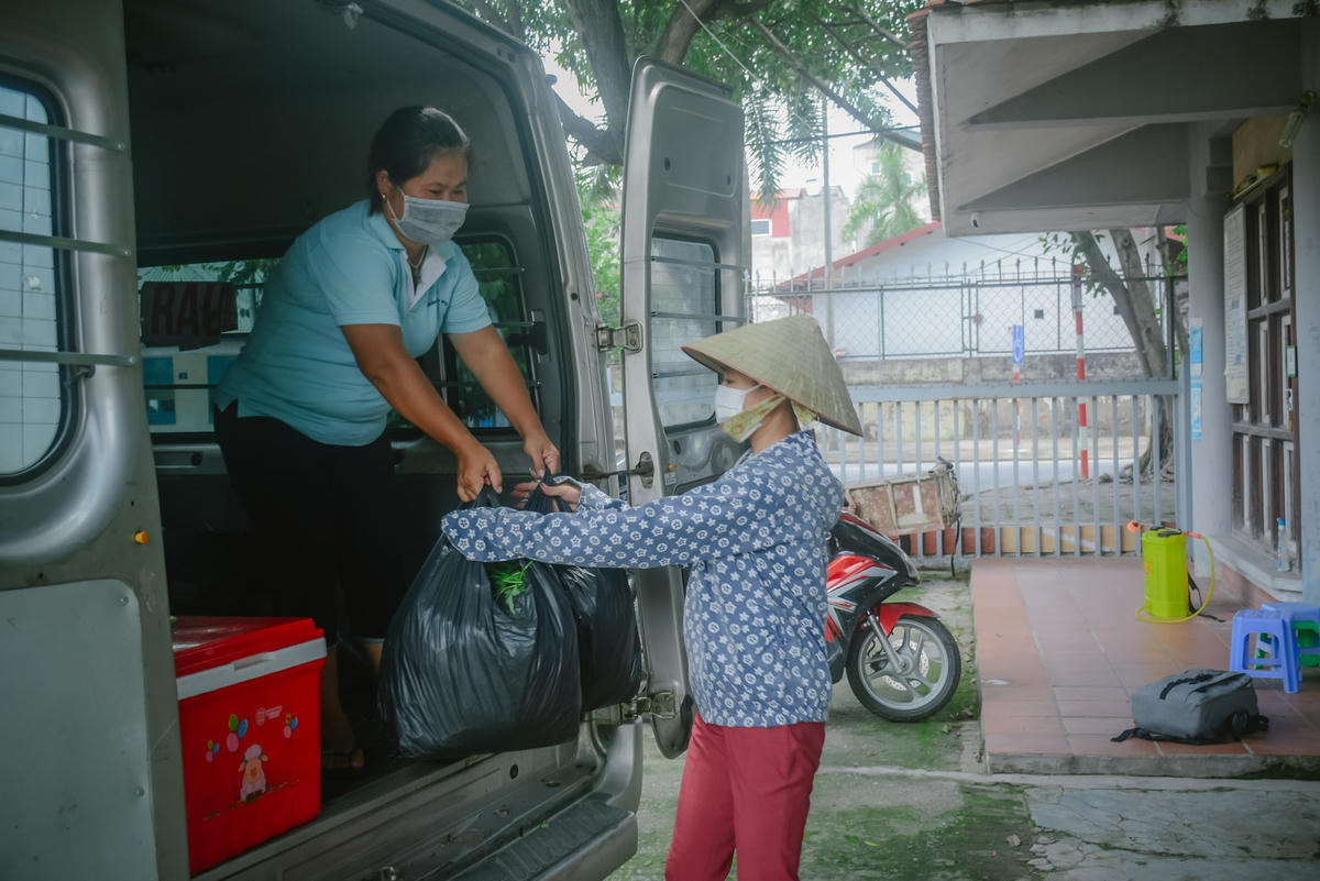 Nhóm sẽ đi từng khu vực, phát rau cho mỗi hộ gia đình. 