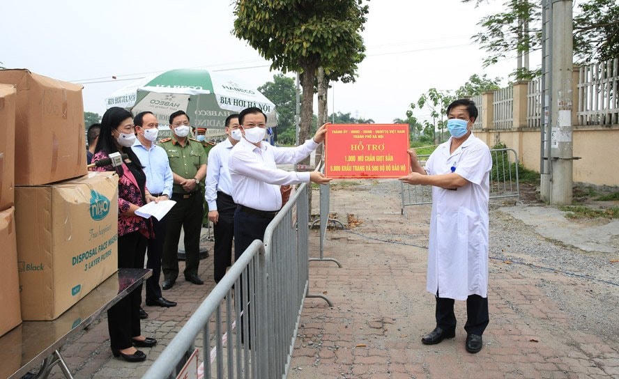 Bí thư Thành ủy Hà Nội Đinh Tiến Dũng và các vị lãnh đạo thành phố Hà Nội trao hỗ trợ cho các y, bác sĩ đang thực hiện nhiệm vụ tại Bệnh viện Bệnh Nhiệt đới Trung ương, cơ sở Kim Chung (huyện Đông Anh), ngày 8/5. Ảnh: HNM.