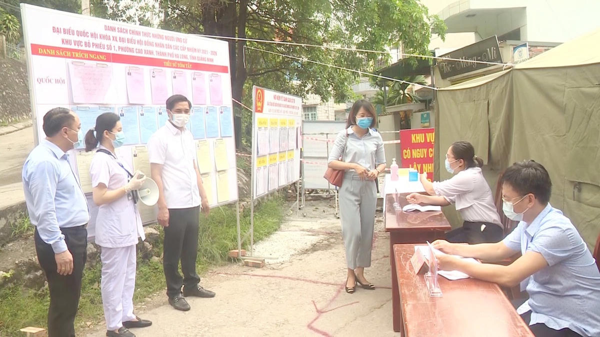Trước khi bỏ phiếu, các cử tri được kiểm tra thân nhiệt, sát khuẩn tay và hướng dẫn bỏ phiểu.