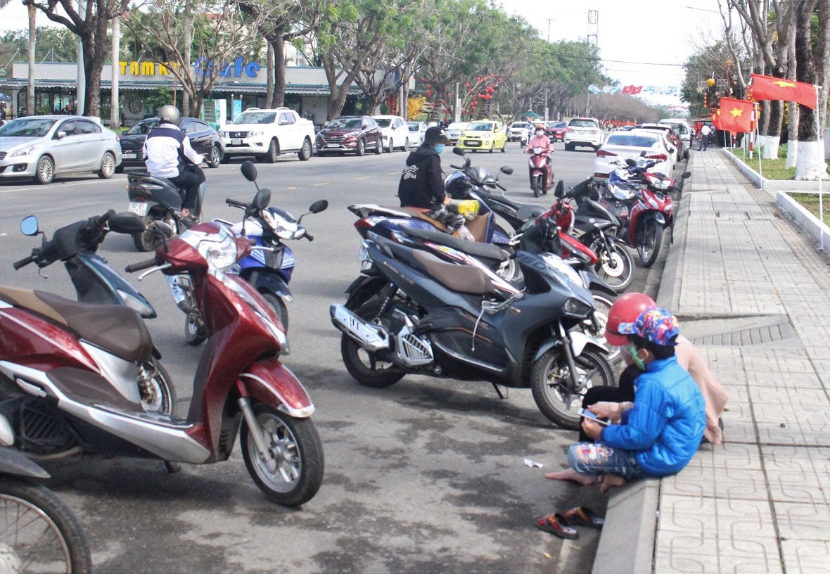 Người dân dựng xe dưới lòng đường Trần Hưng Đạo, TP Tam Kỳ vào rút tiền.