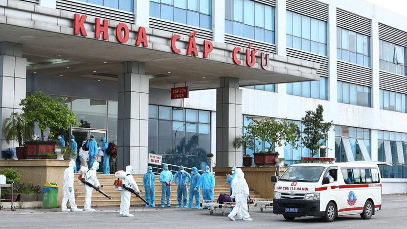 Lực lượng y tế phun thuốc khử khuẩn các công dân khi được đưa về Bệnh viện Nhiệt đới Trung ương cơ sở 2. (Ảnh: Minh Quyết/TTXVN).