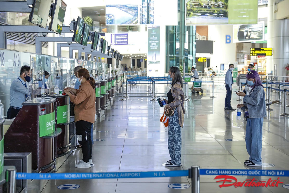 Một vài hành khách check-in, họ đều giữ đúng khoảng cách an toàn. Ảnh: Quang Vinh. 