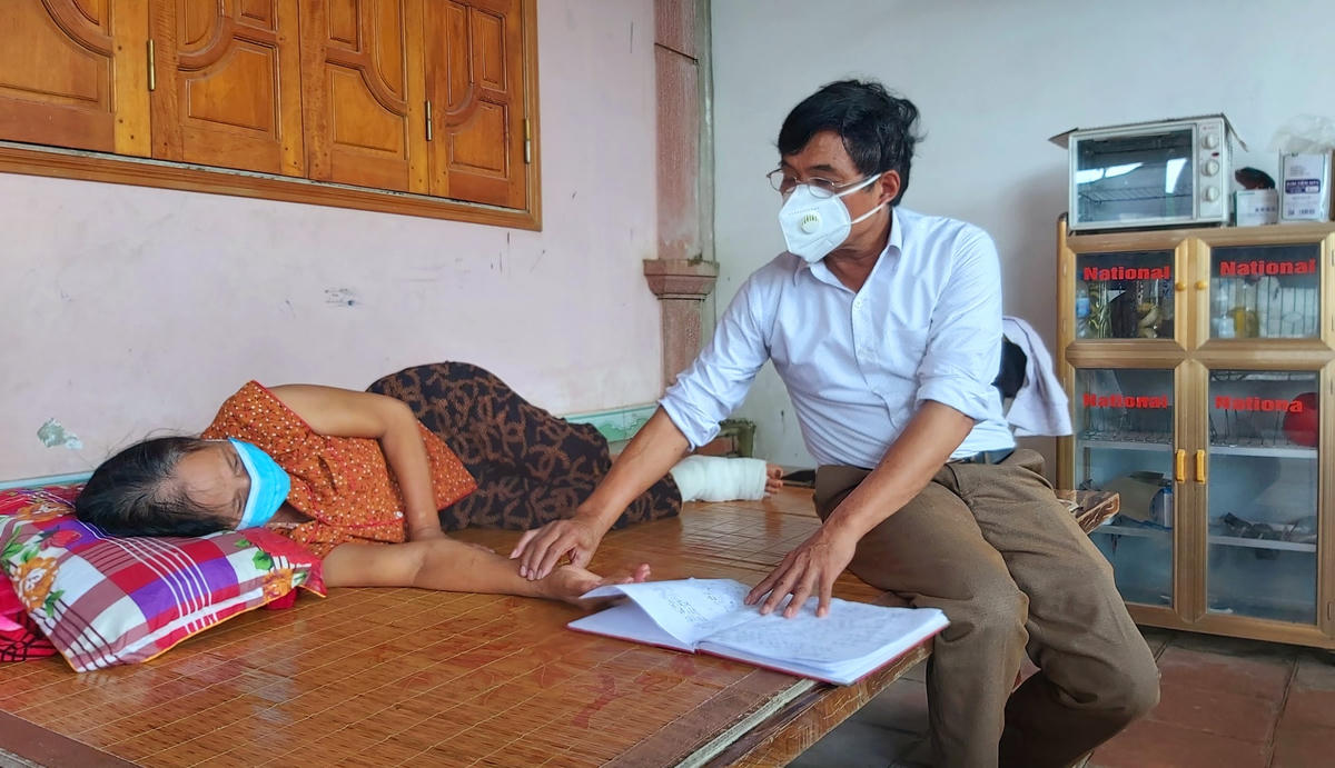 Lương y Bùi Đức Lục khám lại vết thương rắn độc cắn cho bệnh nhân Nguyễn Thị Thảo.