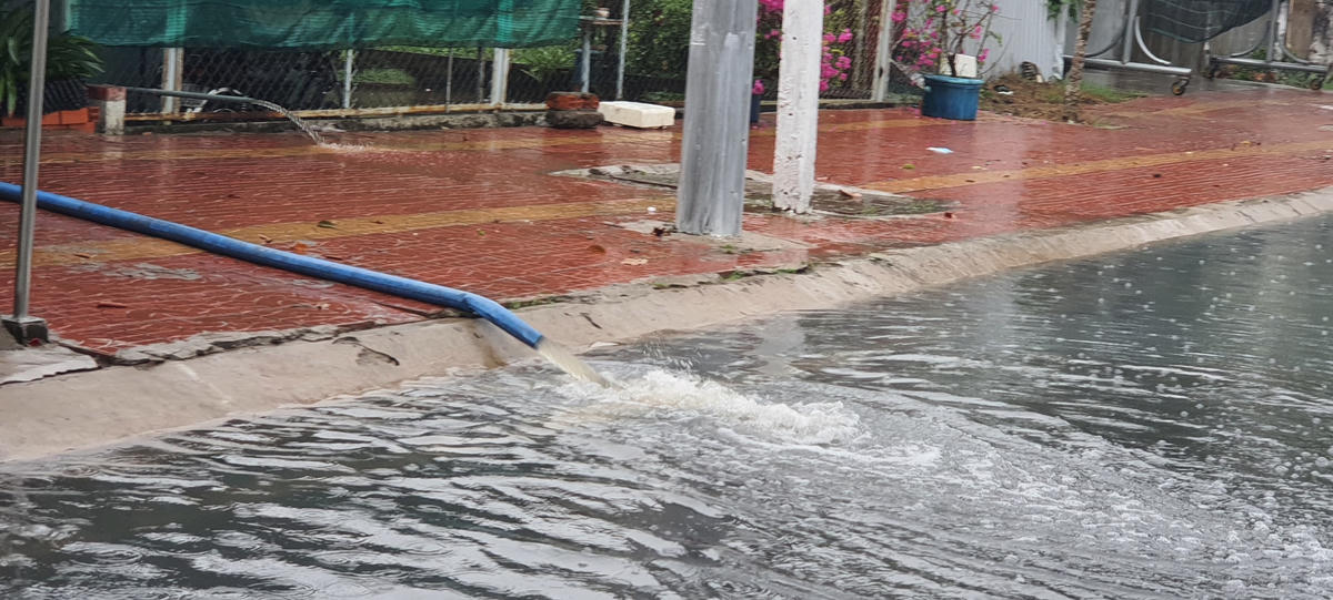 Tại tuyến đường Cao Văn Lầu nước ngập tràn vào nhà người dân phải dùng máy bơm nước ra ngoài.