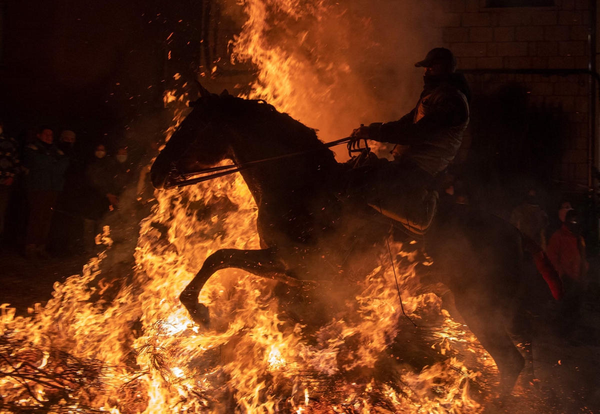 Ngọn lửa “bao vây” một chú ngựa và chủ nhân của nó. Ảnh: AFP / Getty Images.