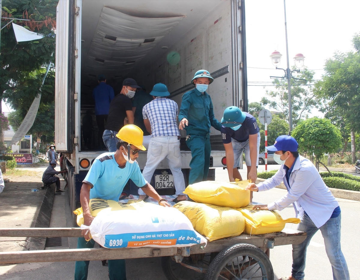 Người dân bốc hàng hóa lên xe để vận chuyển vào TP HCM.
