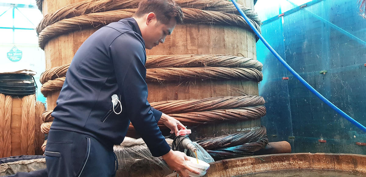 Trong khu nhà kho hỗn hợp khá bề bộn, anh Nguyễn Văn Các, chủ cơ sở sản xuất nước mắm Bà Hoan, đang cẩn thận kiểm tra mẻ nước mắm cốt mới được rút ra từ bể lọc. Cũng như nhà bà Hảo, đây cũng là thời điểm bận rộn nhất trong năm của gia đình anh Các.