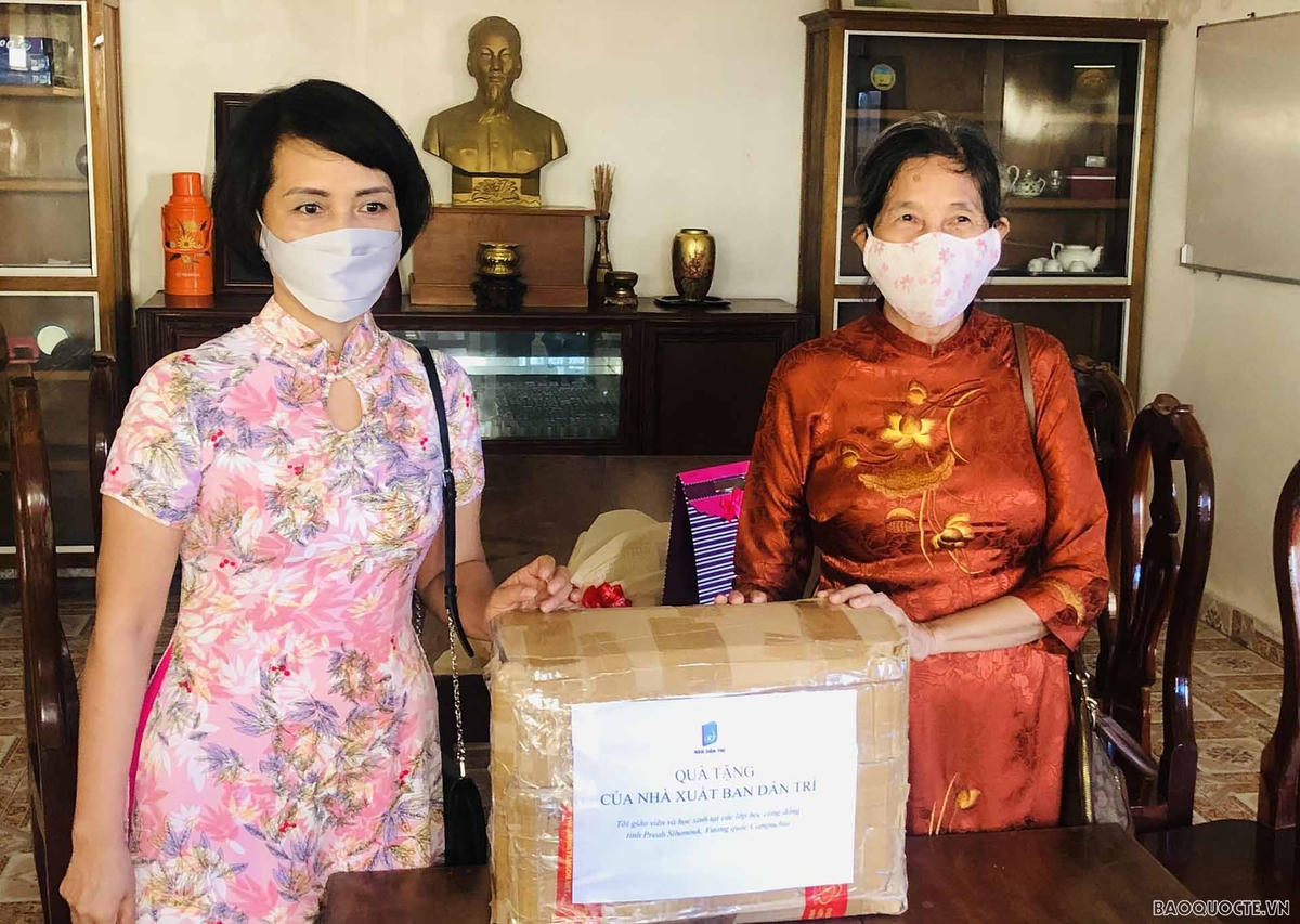 Bà giáo Nguyễn Thị Sương (phải) tiếp nhận một số đầu sách tiếng Việt của Nhà xuất bản Dân trí tặng các cháu thiếu nhi gốc Việt.