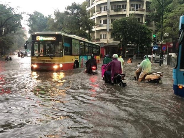 Ôtô, xe máy lưu thông trong biển nước do mưa lớn tại ngã tư Phan Bội Châu-Lý Thường Kiệt. (Ảnh: Lâm Khánh/TTXVN).