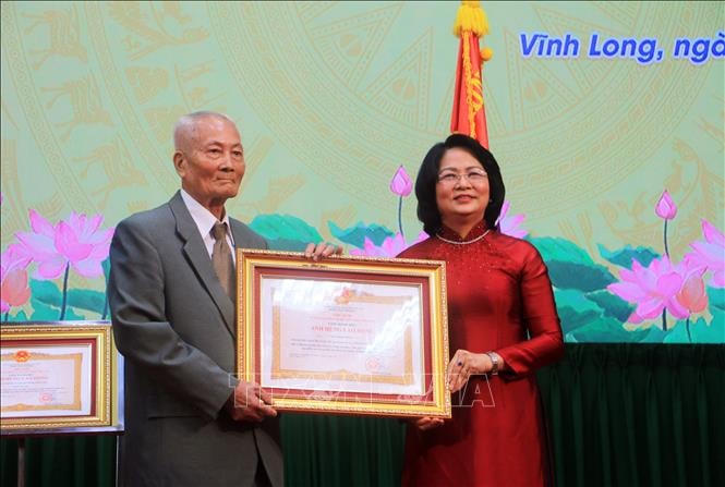 Phó Chủ tịch nước Đặng Thị Ngọc Thịnh trao Bằng chứng nhận danh hiệu Anh hùng Lao động thời kỳ đổi mới cho ông Ngô Ngọc Bỉnh. Ảnh: TTXVN.