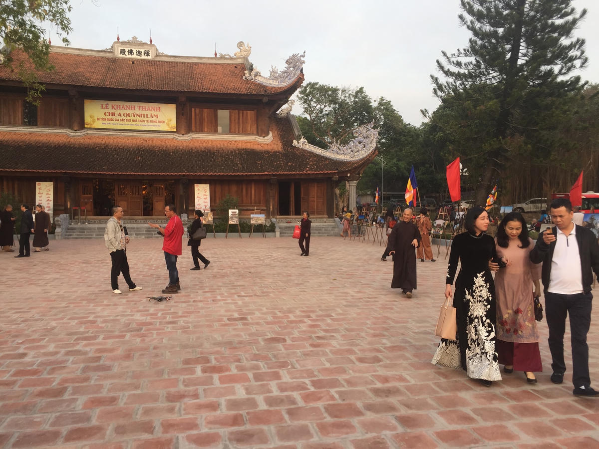 Nhiếp ảnh gia Đỗ Khánh Giang (áo đỏ) trao đổi với đồng nghiệp về chụp ảnh tại ngôi chùa có quy mô bề thế, khang trang.