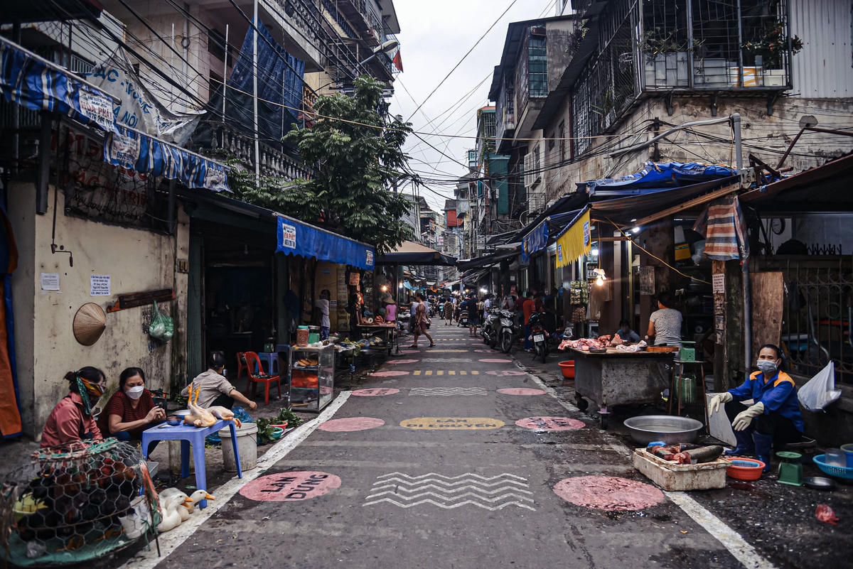 Trong thời thực hiện giãn cách xã hội, lực lượng chức năng đã vẽ ô, kẻ vạch cho chợ Tân Mai (quận Hoàng Mai, Hà Nội) nhằm phân luồng tại con đường dẫn vào chợ.