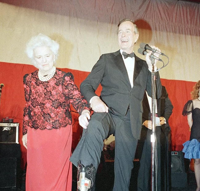 Đệ nhất phu nhân Barbara Bush giúp chồng mình, Tổng thống George Bush, giới thiêu một chiếc ủng có biểu tượng của tiểu bang Texas trong buổi tiệc chiêu đãi ở Washington, ngày 21/1/1989.  