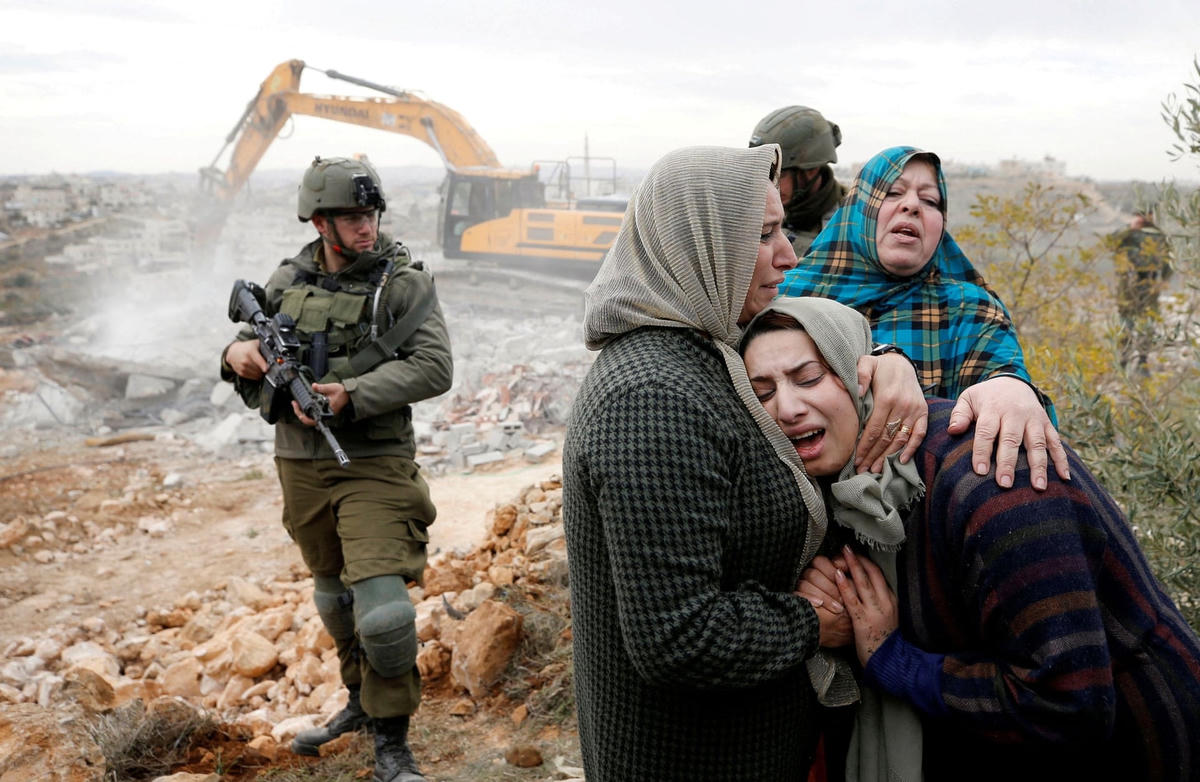 Một phụ nữ Palestine đau khổ khi máy móc của Israel phá hủy ngôi nhà của cô ở West Bank do Israel chiếm đóng. Ảnh: Mussa Issa Qawasma / Reuters.