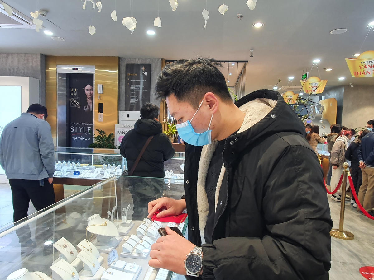 Anh Lê Minh Đức cầm trên tay miếng vàng mới mua tại PNJ.