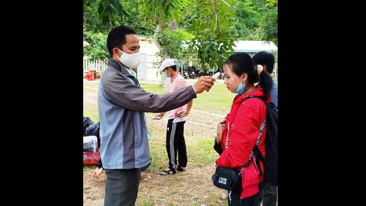 Cán bộ đo thân nhiệt cho thí sinh về điểm thi 51.
