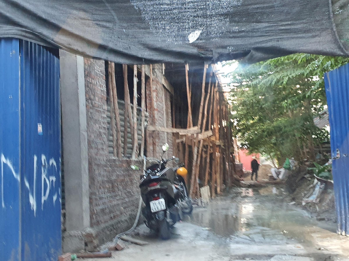 Khu nhà xây trái phép được quây kín tường, cổng chỉ hé mở mỗi khi tập kết vật liệu xây dựng, thợ xây ra vào.