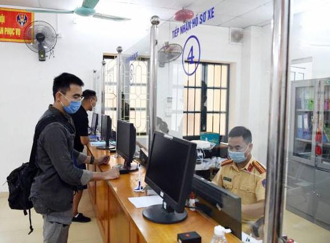 Cảnh sát giao thông đăng ký, cấp biển số xe cho người dân.  Ảnh: Bộ Công an