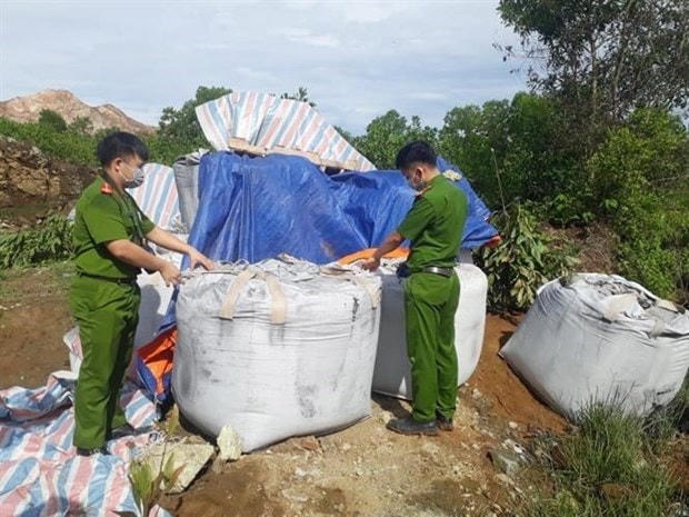 Lực lượng công an kiểm tra, xác minh số chất thải. (Ảnh: TTXVN).