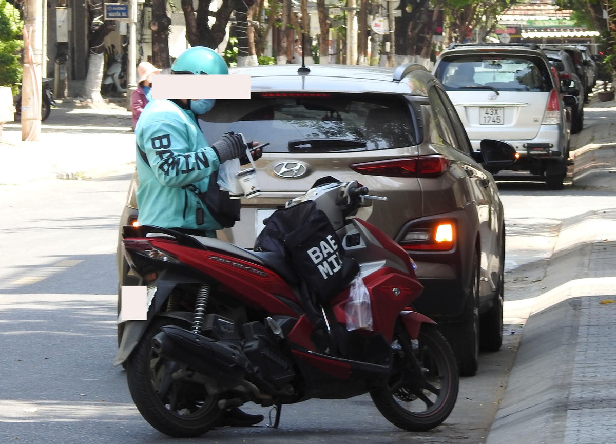 Shipper đang chờ giao hàng cho khách tại khu vực trung tâm TP Đà Nẵng. Ảnh: B.Nguyên.