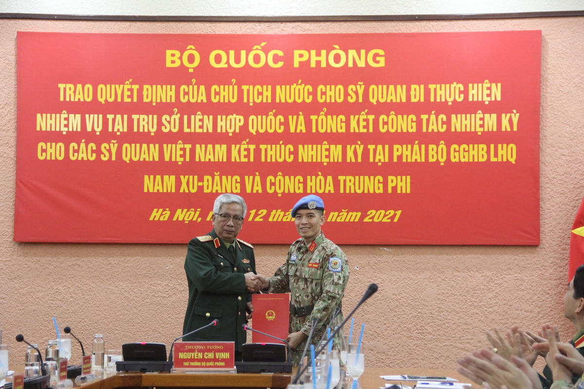 Thượng tướng Nguyễn Chí Vịnh, Thứ trưởng Bộ Quốc phòng, trao quyết định của Chủ tịch nước cho Trung tá Trần Đức Hưởng. Ảnh: Tuổi trẻ.