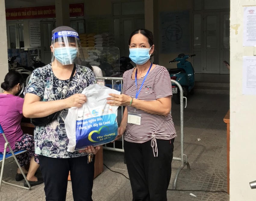 Bà Đinh Thị Minh Huệ (bên phải) tặng quà hỗ trợ người dân gặp khó khăn do ảnh hưởng dịch Covid-19.