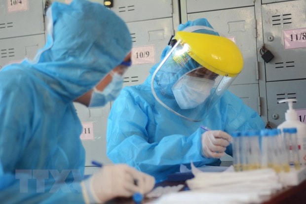 Các nhân viên y tế làm xét nghiệm SARS-CoV-2. Ảnh: TTXVN.