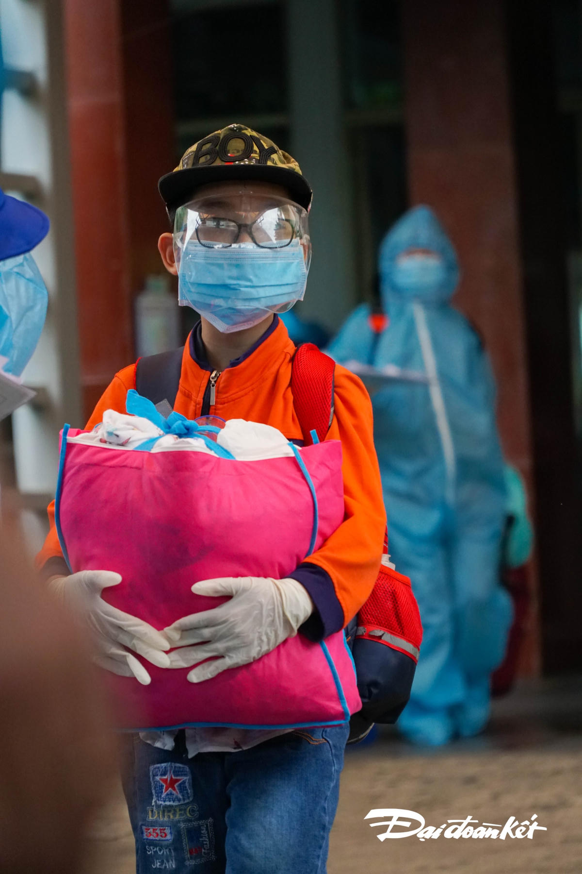 Một em bé tay ôm chặt túi đồ cá nhân.
