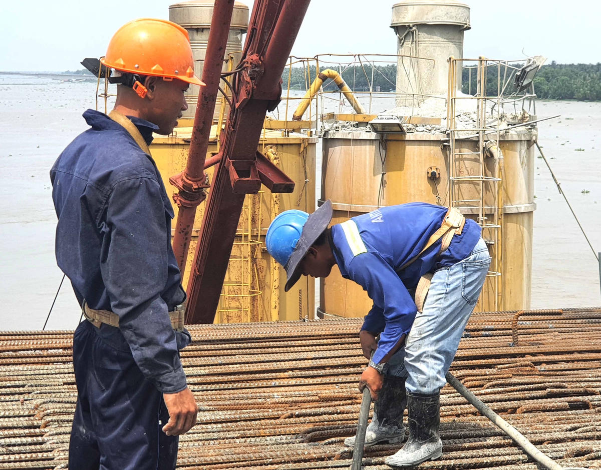 Các công nhân bất kể nắng mưa thực hiện công trình.