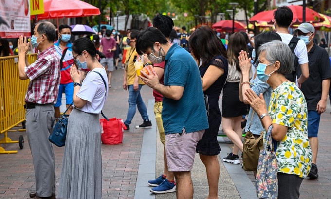 Người dân làm lễ bên ngoài chùa Kwan Im Thong Hood Cho ở Singapore chiều 11/2. Ảnh: AFP.