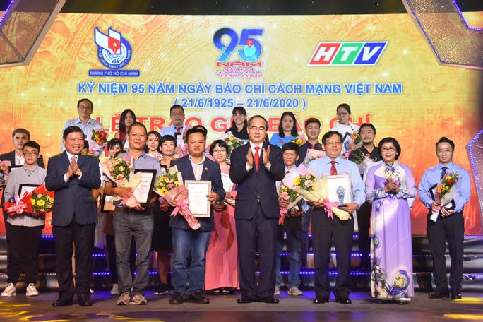 Bí thư Thành ủy TP HCM Nguyễn Thiện Nhân và Chủ tịch UBND TP HCM Nguyễn Thành Phong chụp ảnh lưu niệm với các nhà báo có tác phẩm đạt giải Nhất. (Ảnh: Hồng Phúc).