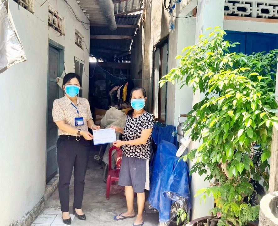 Chủ tịch Mặt trận phường đang đi trao quà cho các hộ nghèo gặp khó khăn trong đại dịch
