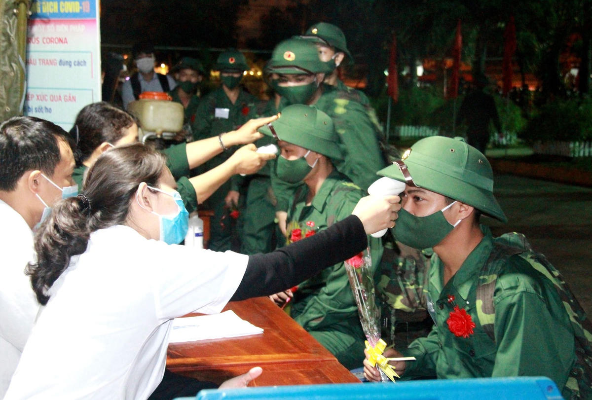 Đo thân nhiệt cho các tân binh ở Quảng Nam.