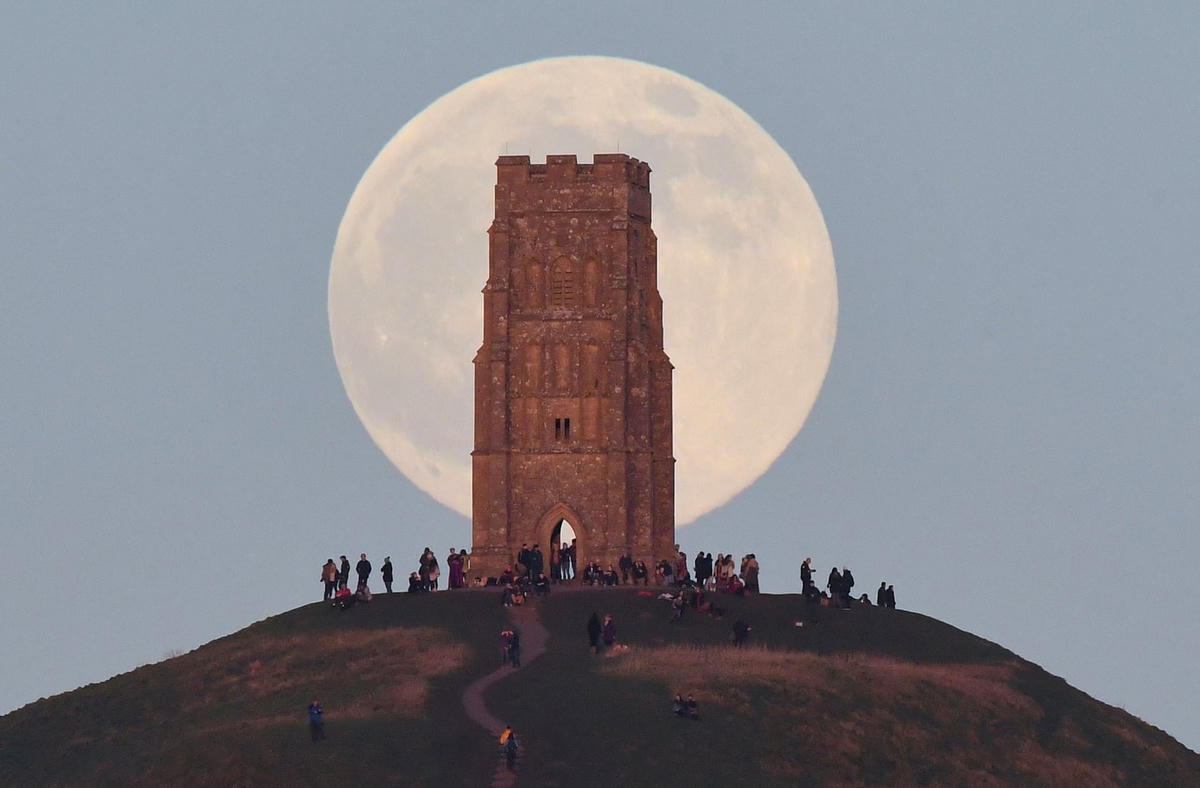 Người dân đến tham quan ngọn đồi Glastonbury Tor khi Trăng mọc ở Glastonbury. Ảnh: Toby Melville / Reuters.