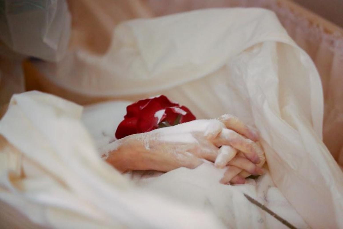 Một bông hồng được đặt trên bàn tay của một người qua đời vì Covid-19 tại một nhà tang lễ ở Brussels, Bỉ ngày 9/4.  