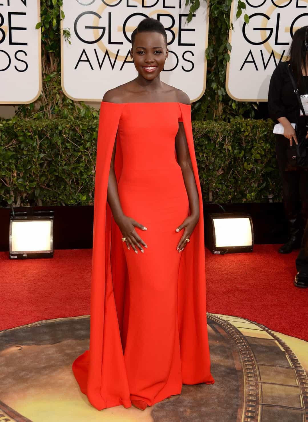 Diện sắc đỏ rực rỡ, Lupita Nyong'o với nụ cười rạng rỡ trên thảm đỏ lễ trao giải Quả cầu vàng năm 2014 ở Beverly Hills, California.  
