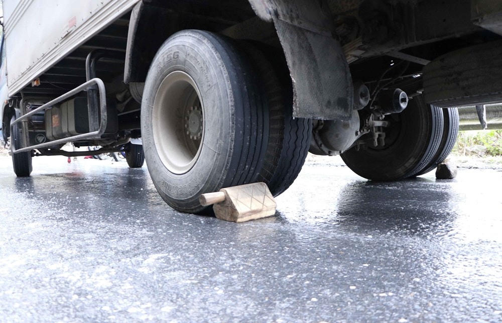 Các chủ xe phải chèn bánh để chống trượt. (Ảnh: Nguyễn Oanh/TTXVN).