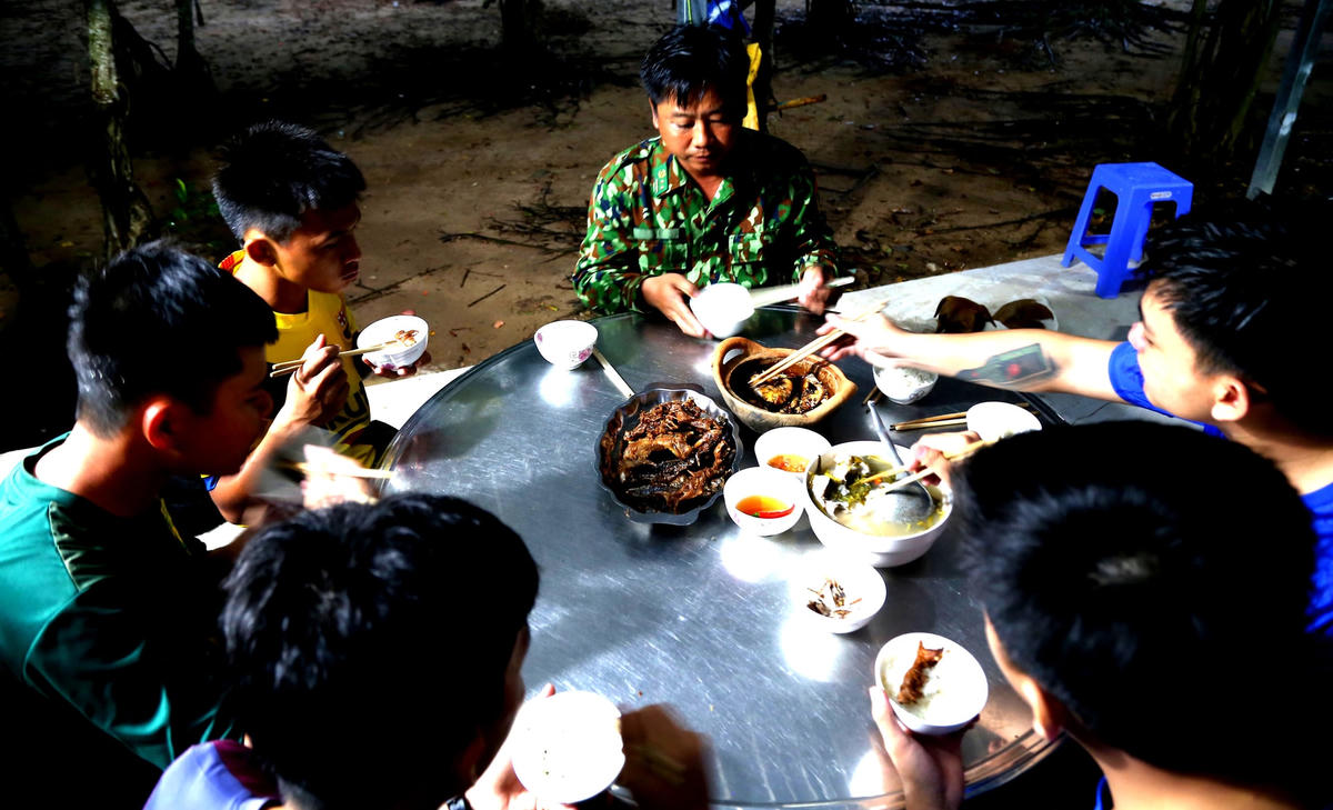 Bữa cơm vội buổi tối của các đồng chí trạm kiểm soát kênh Tân Thành để chuẩn bị đi tuần tra.