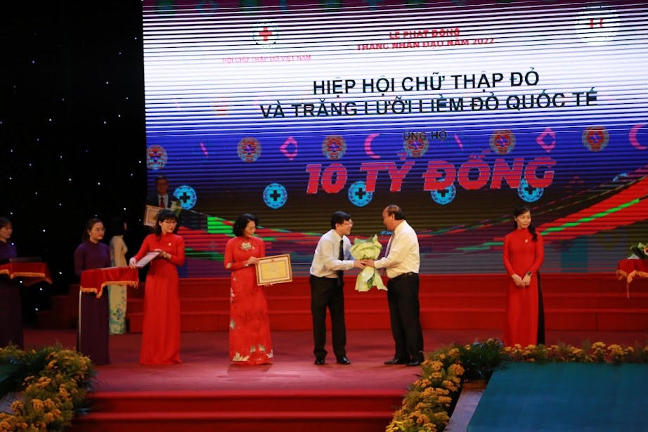 Chủ tịch nước Nguyễn Xuân Phúc tặng hoa, tôn vinh Ban cứu trợ Trung ương đã có những đóng góp tích cực và ủng hộ cho Tháng Nhân đạo năm 2022.