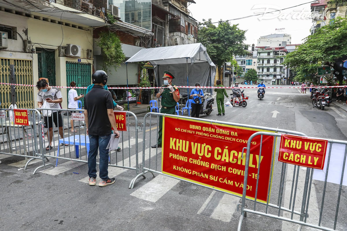 Tại các chốt cứng, người dân vẫn được nhận đồ tiếp tế do người thân gửi. Lực lượng chức năng đã sắp xếp các bàn để giao đồ và thực hiện kiểm soát 24/7. Ảnh: Quang Vinh. 