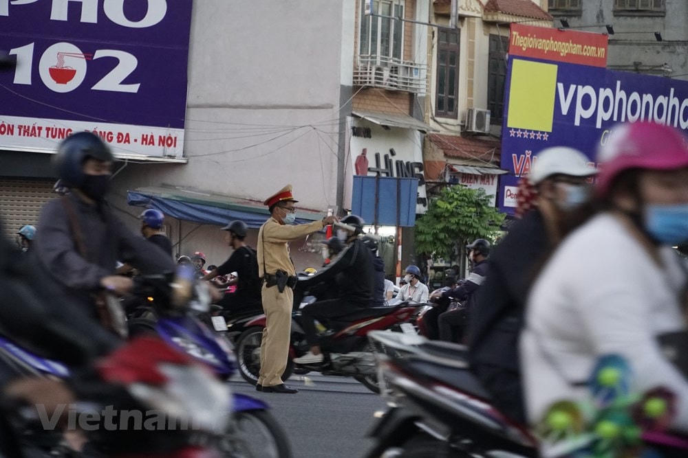 Đội Cảnh sát giao thông số 3, Phòng CSGT Công an Hà Nội, triển khai lực lượng cắm chốt tại nút giao này. ''Ùn tắc có thể xảy ra bất cứ lúc nào trong ngày nên chúng tôi luôn phải sẵn sàng phân luồng chứ không cố định vào các khung giờ cao điểm như những nơi khác,'' một chiến sĩ nói. (Ảnh: Minh Hiếu/Vietnam+).