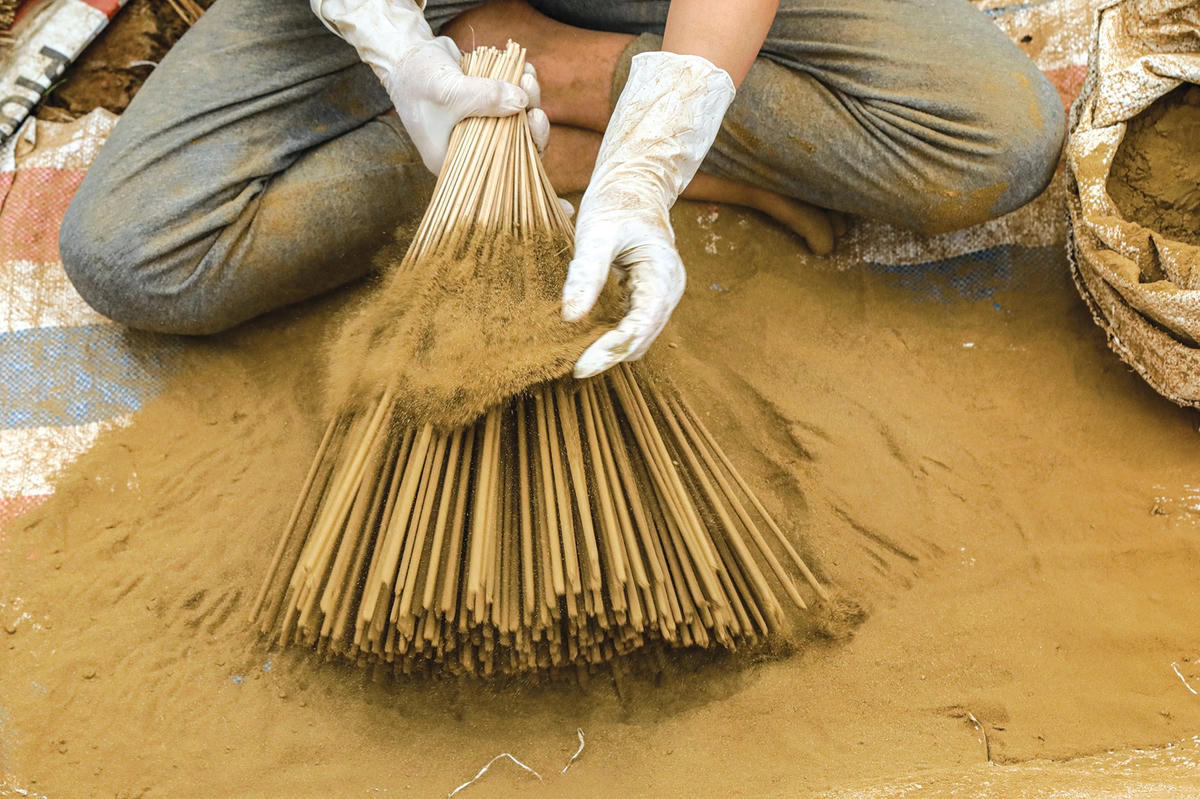 Công đoạn nhúng hương vào nước keo rồi lăn tẩm với hỗn hợp mùn cưa và bột trầm.