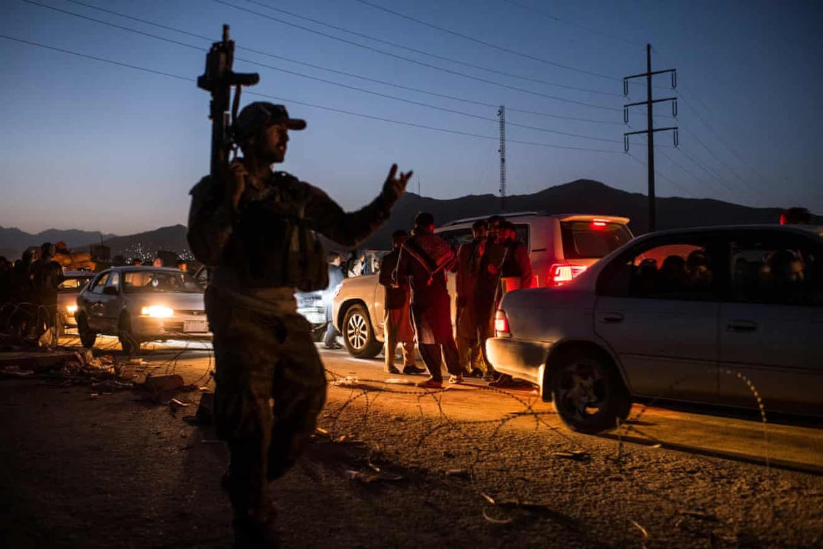 Các thành viên của đơn vị bán quân sự Afghanistan do CIA hậu thuẫn đang cố gắng kiểm soát đám đông người dân cố gắng trèo qua cổng phía Tây Bắc của sân bay. Những người lính đã sử dụng súng cảnh báo người dân. (Ảnh: Andrew Quilty)